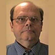 Serious-looking balding man with glasses